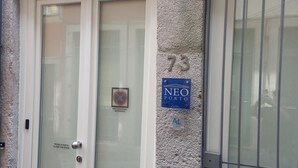 A building entrance with a white door, a metal gate, and a sign reading "NEO PORTO". - Neo Porto Family & Friends local accommodation. (União de Freguesias do Centro)