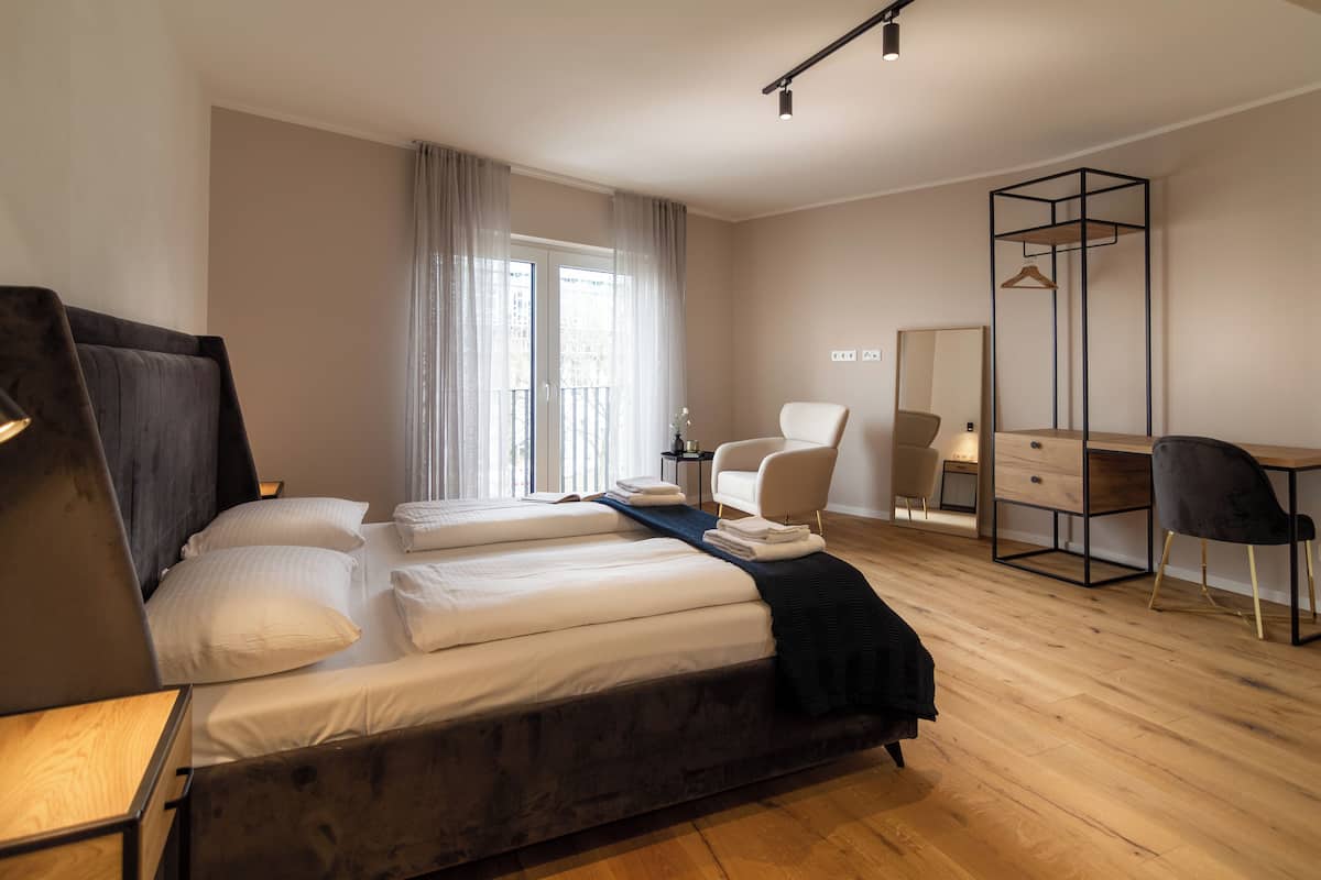 Ett modernt hotellrum med en stor säng, ett skrivbord, en stol och en garderob.