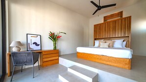 A modern bedroom with a bed, a desk, and a chair. - Modern Villa Overlooking Lush National Park (Huatulco)