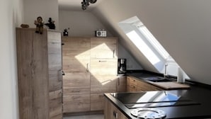 Una cocina moderna con armarios de madera, encimera negra y tragaluz.