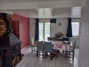 Ein Essbereich mit Kamin, einem Tisch mit Stühlen und einem Fenster mit Vorhängen.