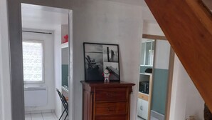 Ein Zimmer mit einem Holzkästen, einem gerahmten Bild und einem Fliesenboden.