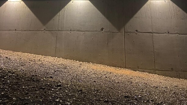 Eine Betonwand mit zwei rechteckigen Leuchten.