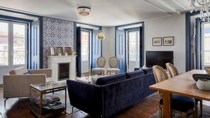A living room with a blue sofa, a wooden coffee table, and a fireplace. - Master Deco Gem in Baixa (Lisboa)