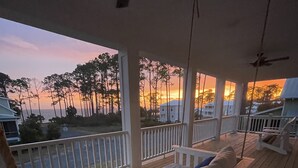 A wooden deck with a white bench and a ceiling fan. - Endless Summer: Double porches w/ Ocean views, resort pool! 1-min walk to beach! (Saint Teresa)