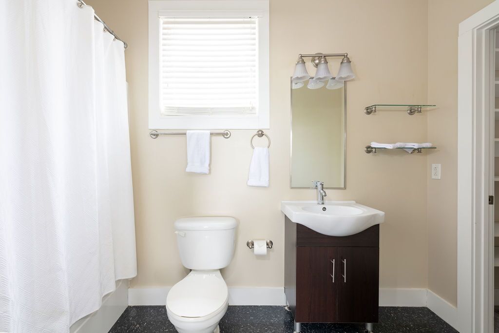 Un baño con inodoro, lavabo y espejo.