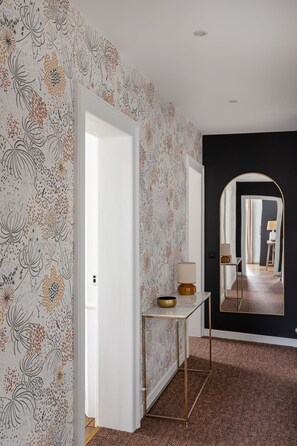 Stunning hallway with floral wallpaper, console table, and large mirror.