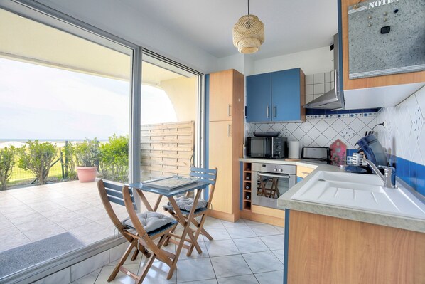 Una cocina moderna con un ventanal grande, un comedor con mesa y sillas, y vistas al exterior.
