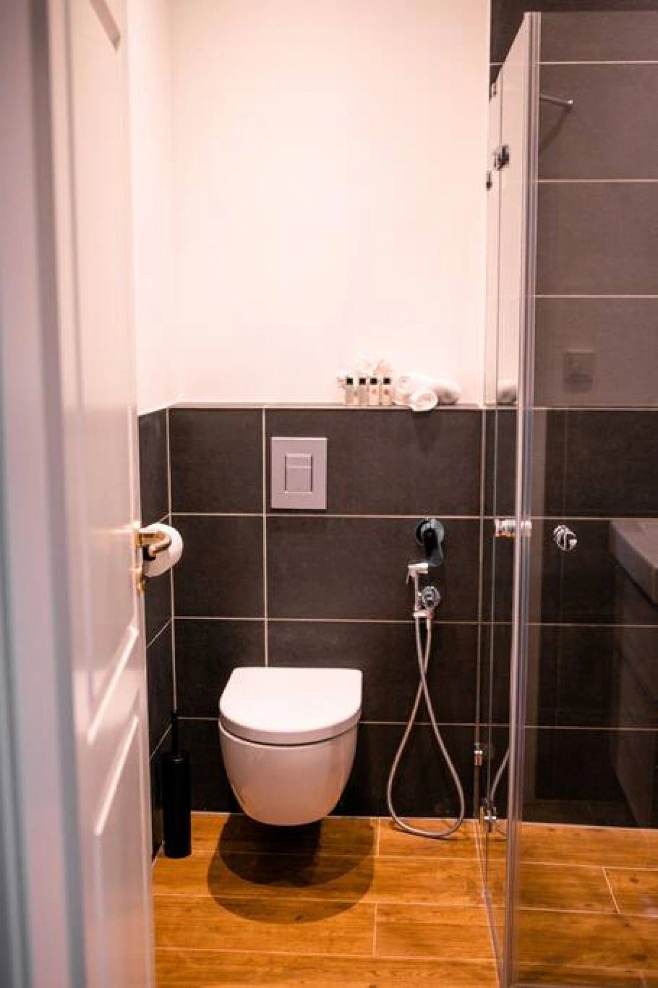 A bathroom with a toilet, a shower, and a sink.