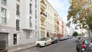 En rad med flerfamiljshus, och längs gatan står parkerade bilar.