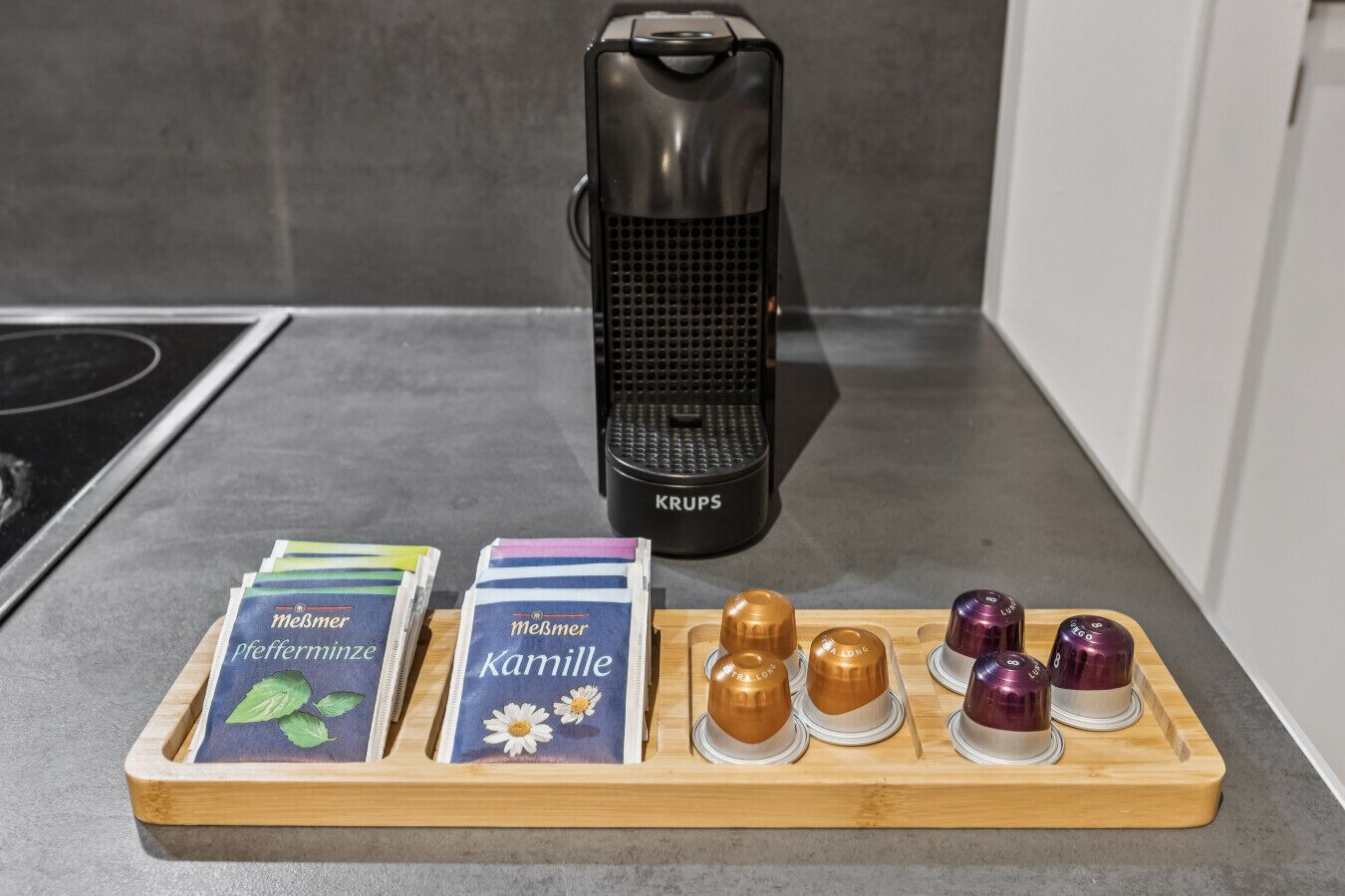 En köksbänk med en kaffebryggare, ett fat med tepåsar och en uppsättning tekannor med infuseringsfunktion.