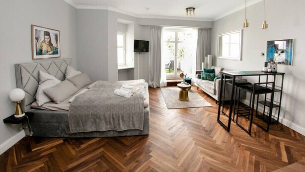 A modern bedroom with a large bed, a desk, and a TV. - Arbio I Cozy Apart in Charlottenburg (Berlin)