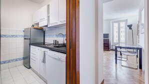 Eine moderne Küche mit weißen Schränken, einem Edelstahl-Kühlschrank und einem Geschirrspüler von Bosch.