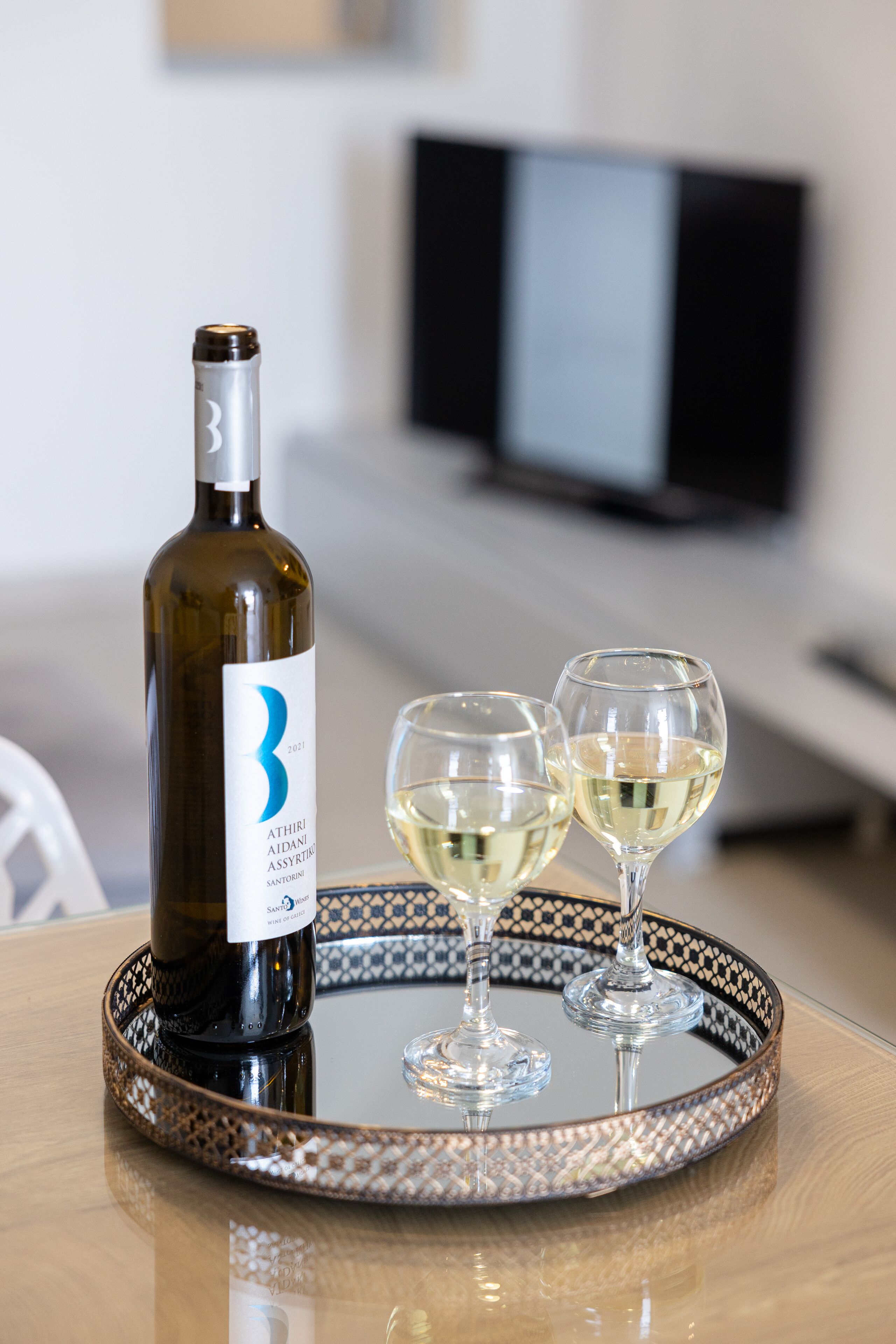 Une bouteille de vin sur un plateau, accompagnée de deux verres.