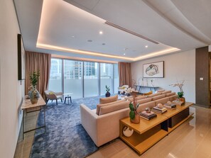 A modern living room with a sofa set, a coffee table, and a dining area with a table and chairs.
