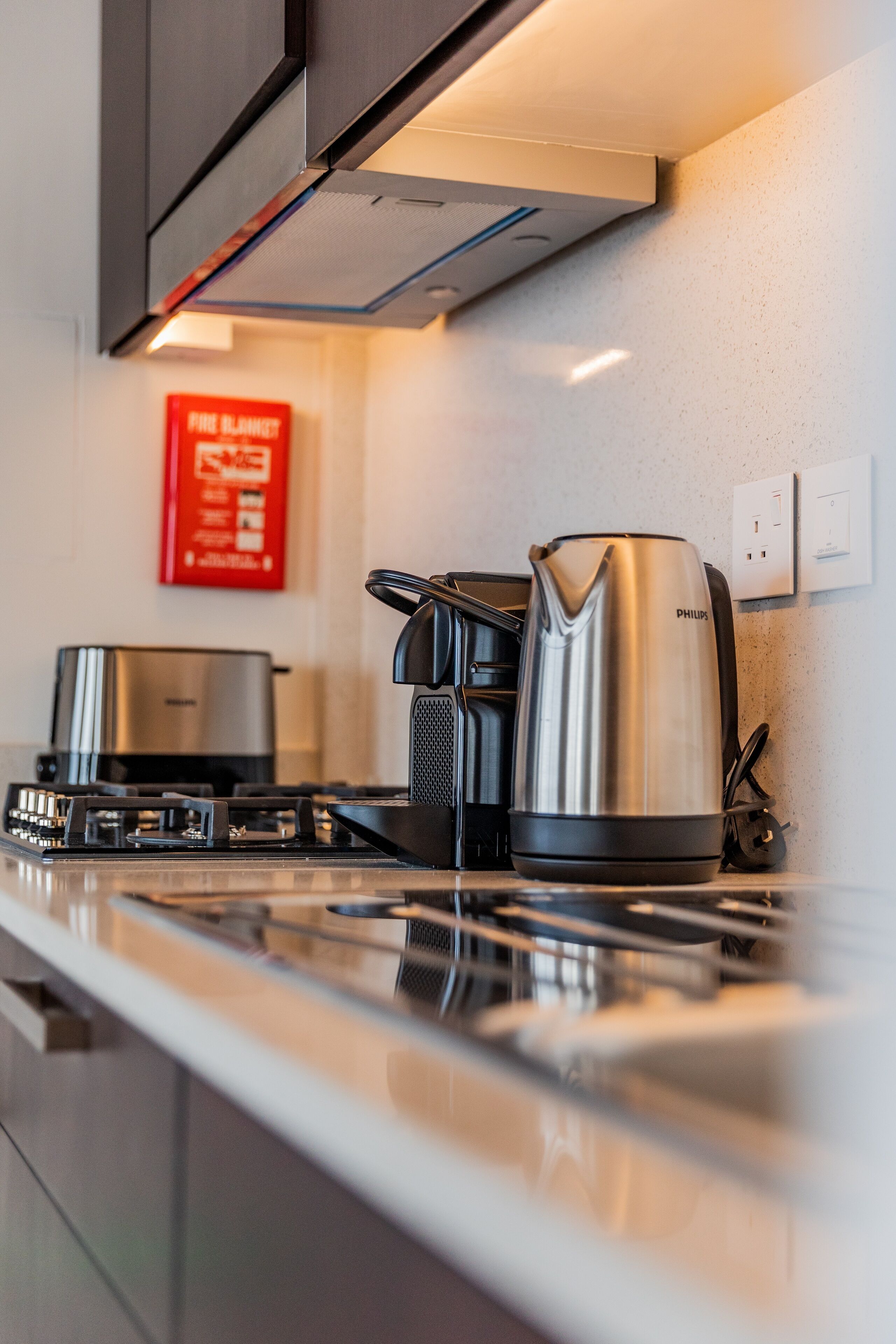 A modern kitchen with a stainless steel kettle, a coffee maker, and a toaster.