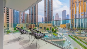 A modern hotel room with large windows offering a view of a cityscape, including high-rise buildings and a road. - EDEN'S Homes & Villas - Opera Grand (Dubai)