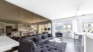 A modern living room with a sofa, coffee table, and dining area. - Muette - Lamartine 1bdr by B'Your Home (Paris)