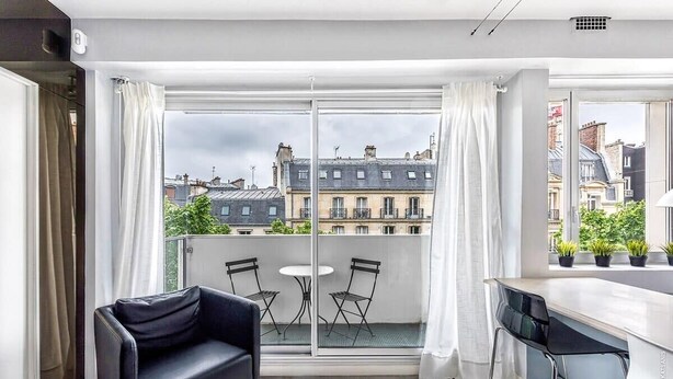 A modern apartment with a balcony, a black sofa, a small table, and a bar area. - Muette - Lamartine 1bdr by B'Your Home (Paris)