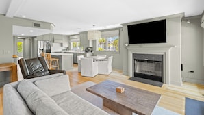 Een moderne woonkamer met een bank, salontafel en open haard.