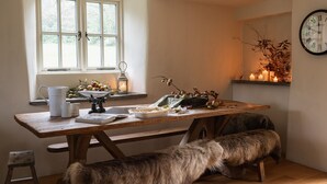 Una cocina acogedora con una mesa de madera, un banco y una ventana con cortinas.
