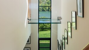 Un intérieur moderne avec une porte vitrée centrale donnant accès à une vue extérieure panoramique.