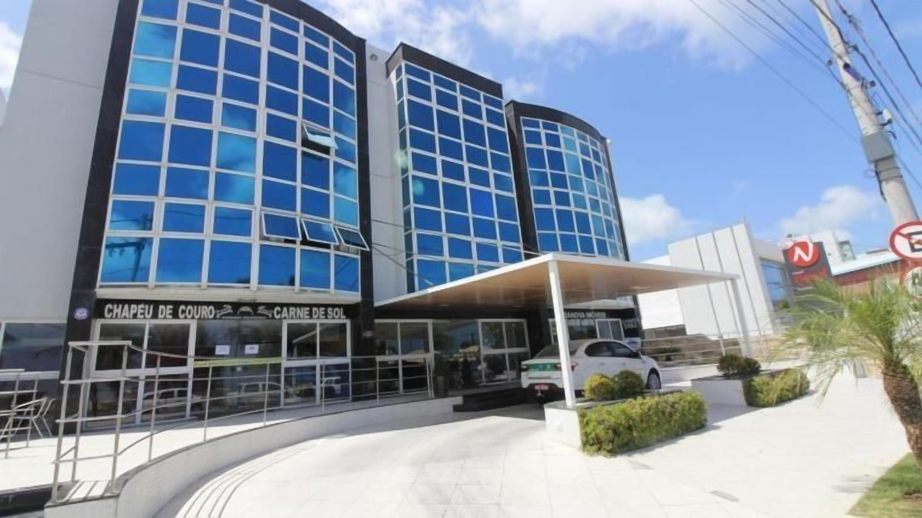 A modern building with a covered entrance and a car parked in front.