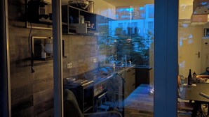 Une cuisine moderne avec une porte vitrée donnant sur un balcon.