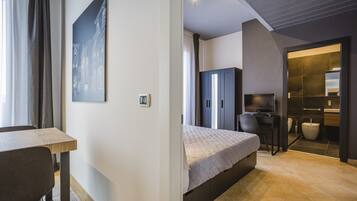 Un dormitorio moderno con cama, escritorio y baño.