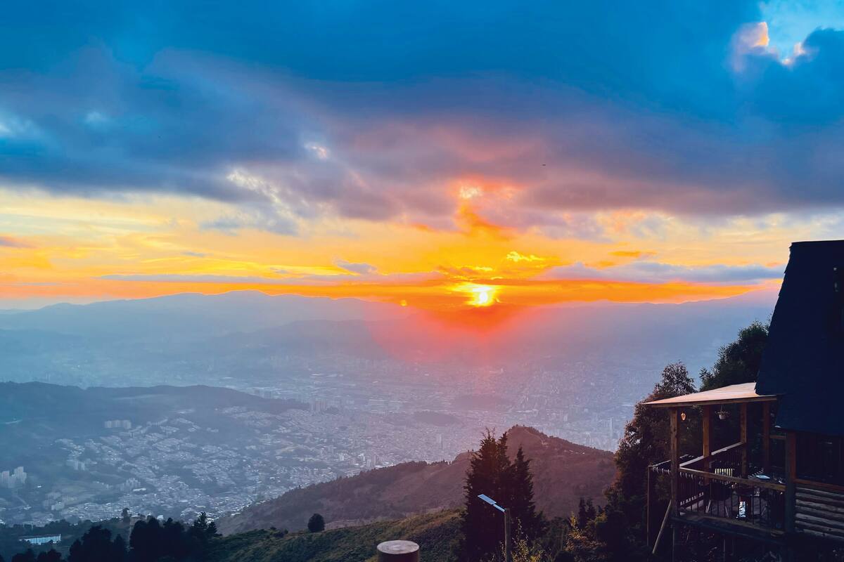 A sunset view from a mountain with a wooden cabin structure.