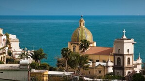 A coastal town with a prominent church featuring a large dome and a bell tower. - Splendid Suite with Sea View Terrace  (Positano)