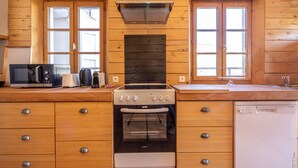 A kitchen with wooden cabinets, a stove, an oven, a microwave, and a dishwasher. - Maison 116 - Hypercentre - Gaillac (Gaillac)