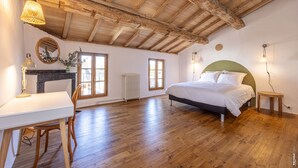 A bedroom with a wooden ceiling, a bed, a desk with a chair, and a radiator. - Maison 116 - Hypercentre - Gaillac (Gaillac)