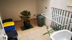 A small balcony with a potted plant, a trash bin, and a drying rack. - Finely renovated apartment in the center of Grottaglie (Grottaglie)