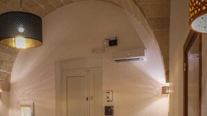A cozy room with a yellow sofa, a dining table with chairs, and a chandelier. - Finely renovated apartment in the center of Grottaglie (Grottaglie)