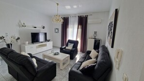 Deluxe Apartment | Living area | 140-cm Smart TV with cable channels, TV - Doukas Aparthotel (Pangaio)