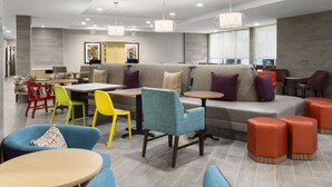A modern lounge area with seating arrangements, tables, and pendant lighting.