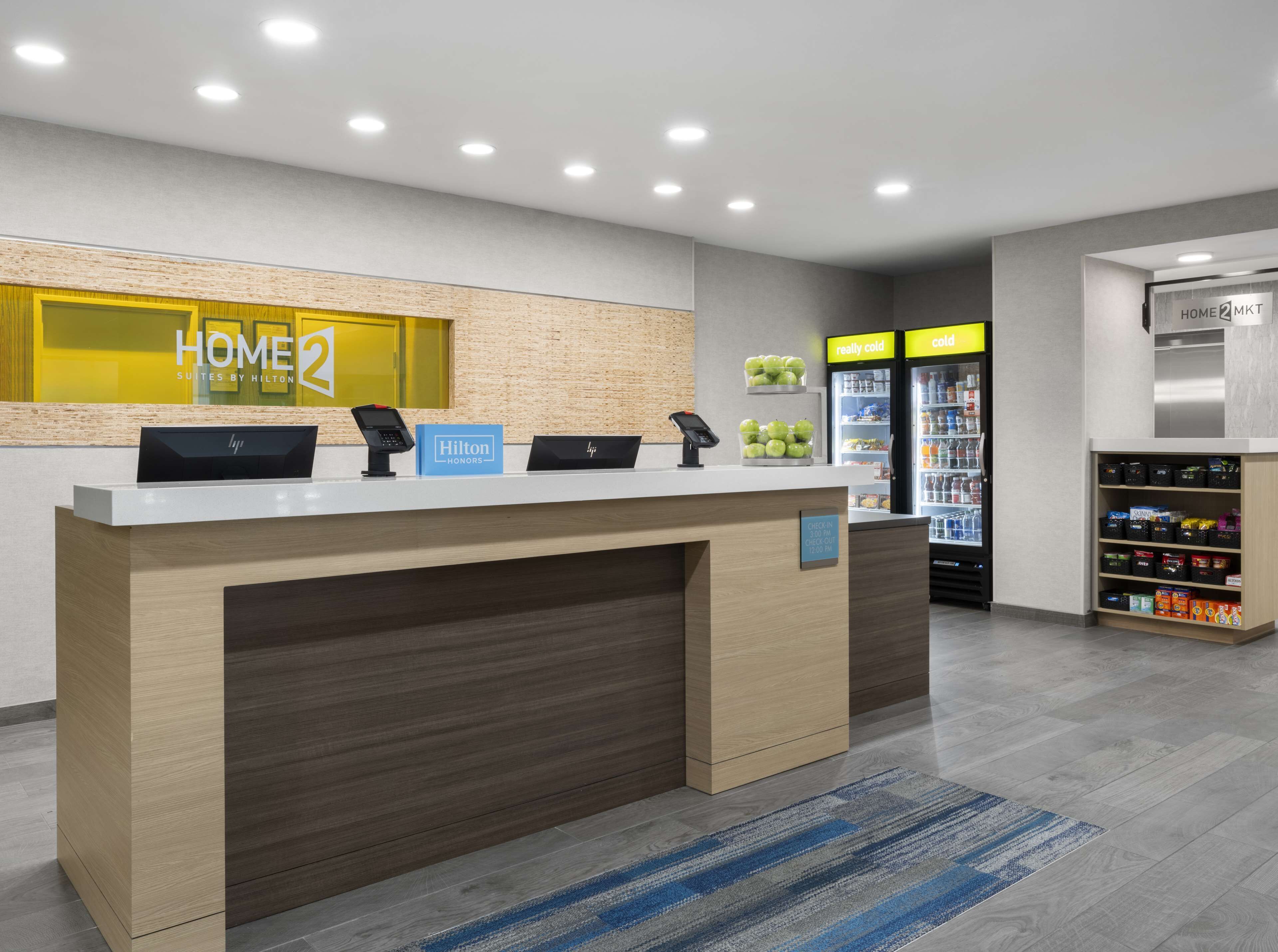A hotel reception area with a counter, a minibar, and a refrigerator.