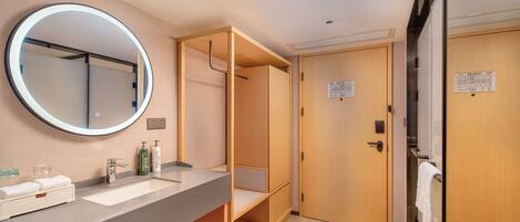 Un baño moderno con un espejo grande, un lavamanos y armarios de madera.