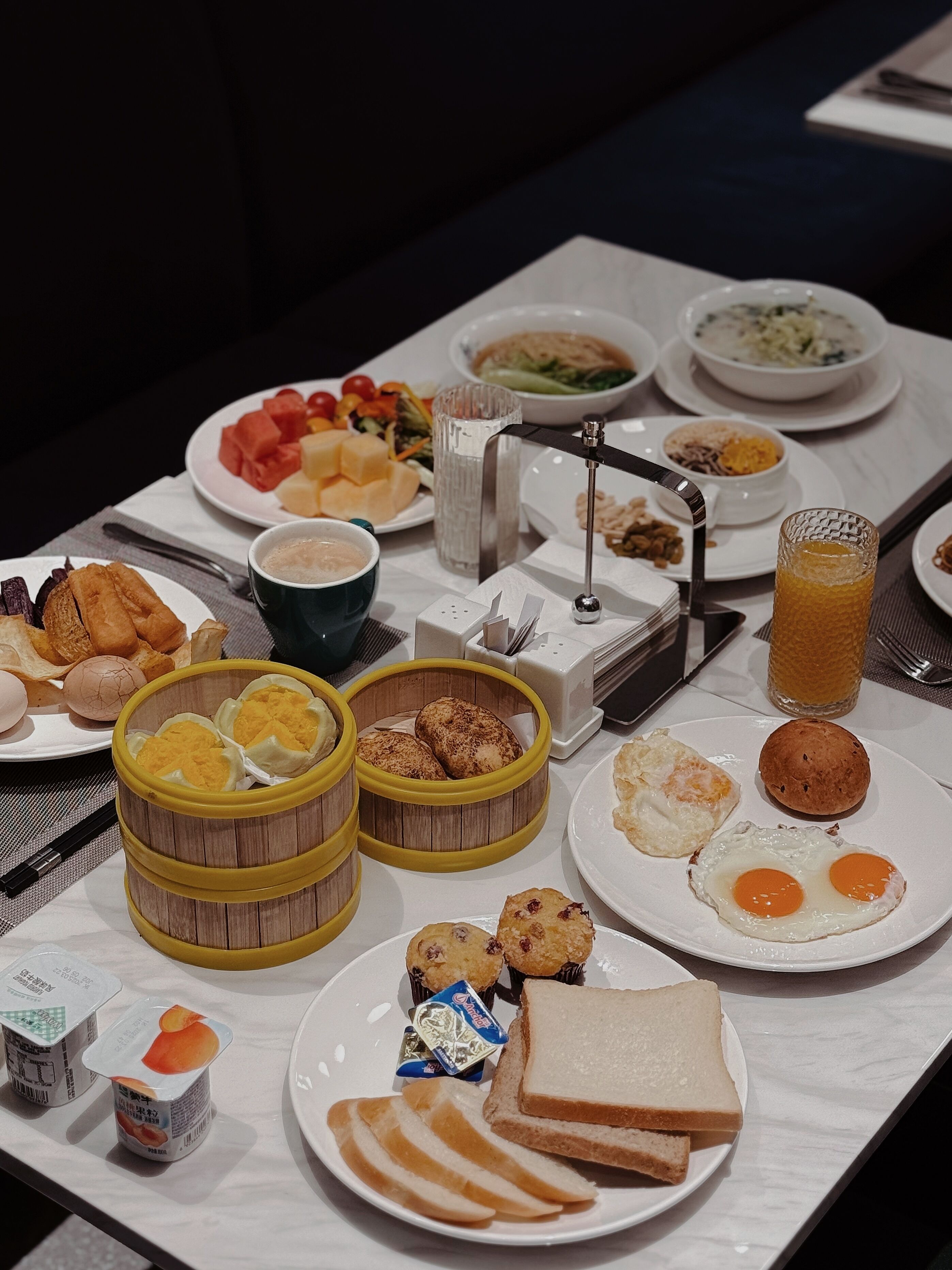 A breakfast buffet with various dishes including eggs, toast, and fruit.