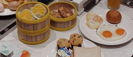A breakfast buffet with various dishes including eggs, toast, and fruit.