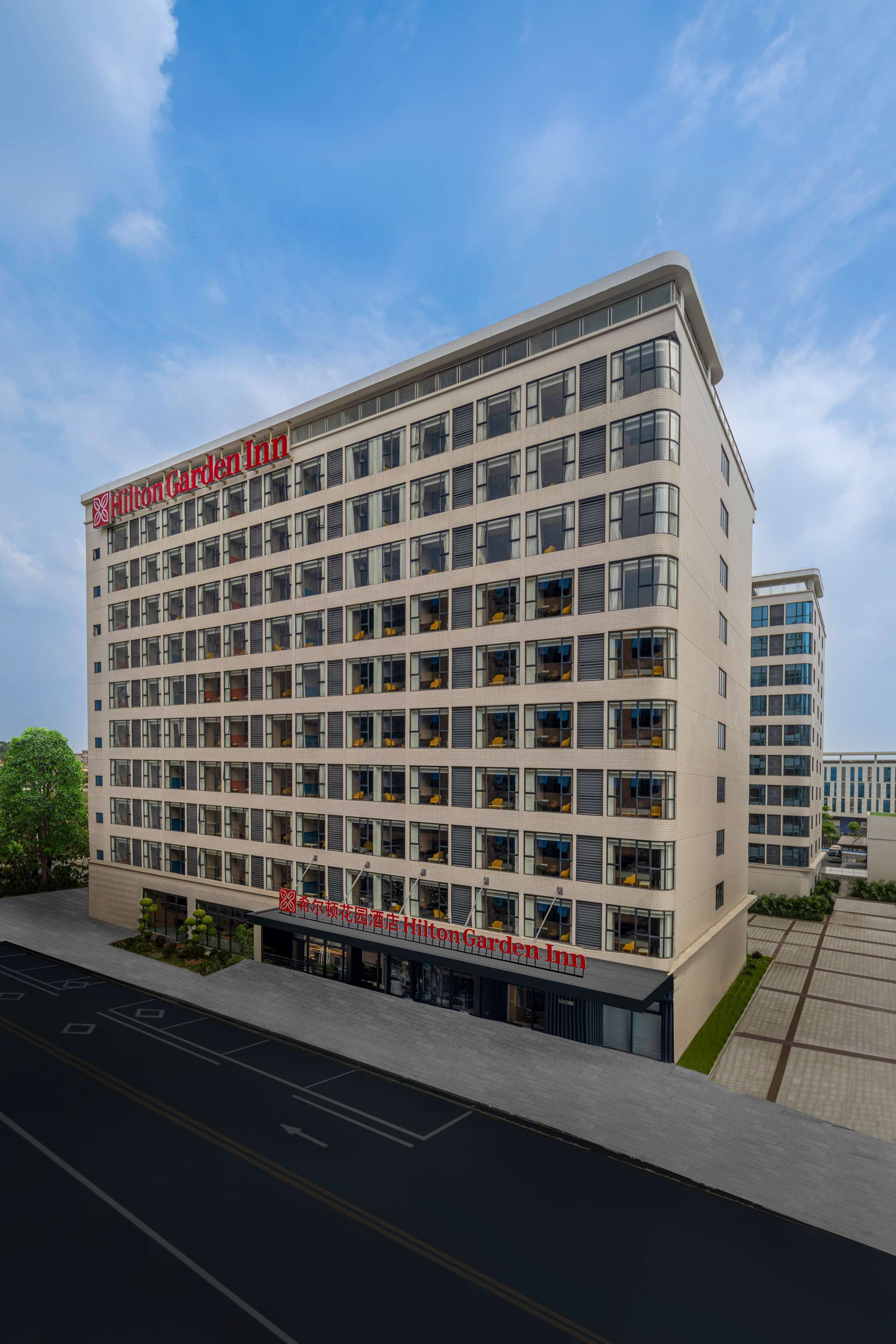 Un Hilton Garden Inn de varios pisos con un diseño arquitectónico moderno, que presenta una señalización llamativa y una fachada limpia y ordenada.
