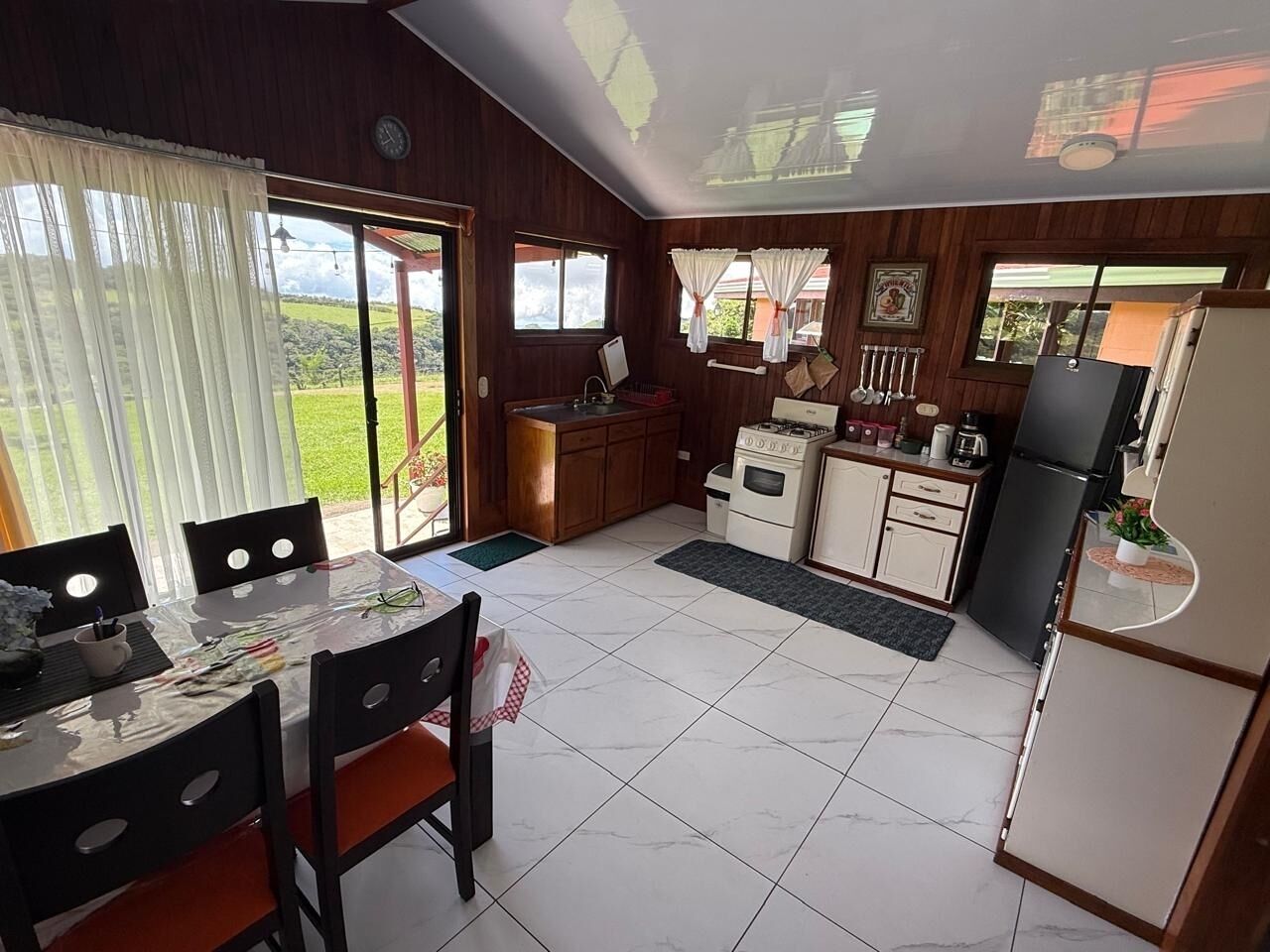 Una cucina compatta con angolo ristoro, pensili in legno e frigorifero.