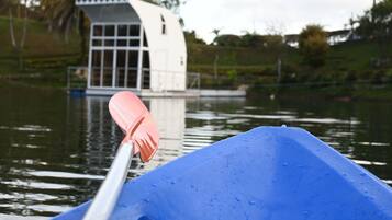 A blue canoe with a paddle on the water.