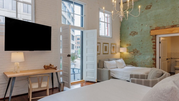 Une chambre moderne avec un grand lit, un bureau et une télévision.