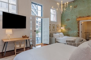 Een moderne slaapkamer met een groot bed, een bureau en een televisie.