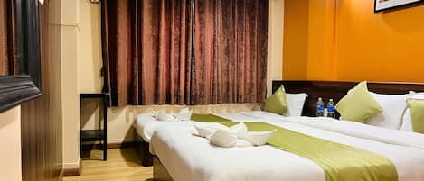 A hotel room with a large bed, a desk, and a painting on the wall.