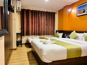 Une chambre d’hôtel avec un grand lit, un bureau et un tableau au mur.