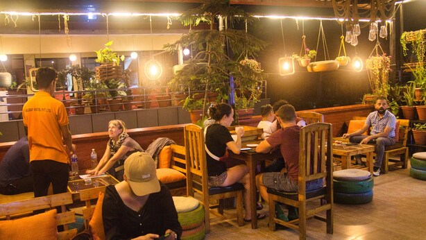 A cozy indoor seating area with wooden furniture and potted plants. - Holiday Hostel (Kathmandu)