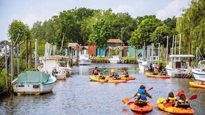 A marina with several kayaks and boats docked along the water. - La Cabane N°20, Plage à Pieds (Arès)